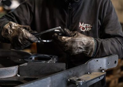 Operaio al lavoro su un componente saldato, applicando precisione e competenza durante il processo di saldatura.