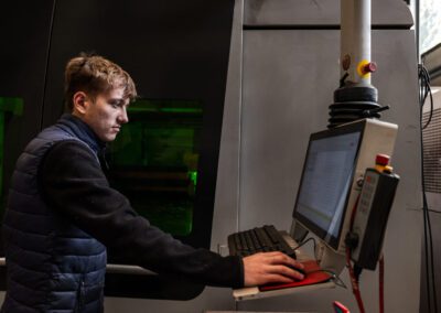 Operatore che monitora il processo di taglio laser su schermo, assicurando precisione e qualità durante la lavorazione.