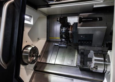 Componente metallico in fase di lavorazione al tornio, con il macchinario in azione per garantire precisione e qualità